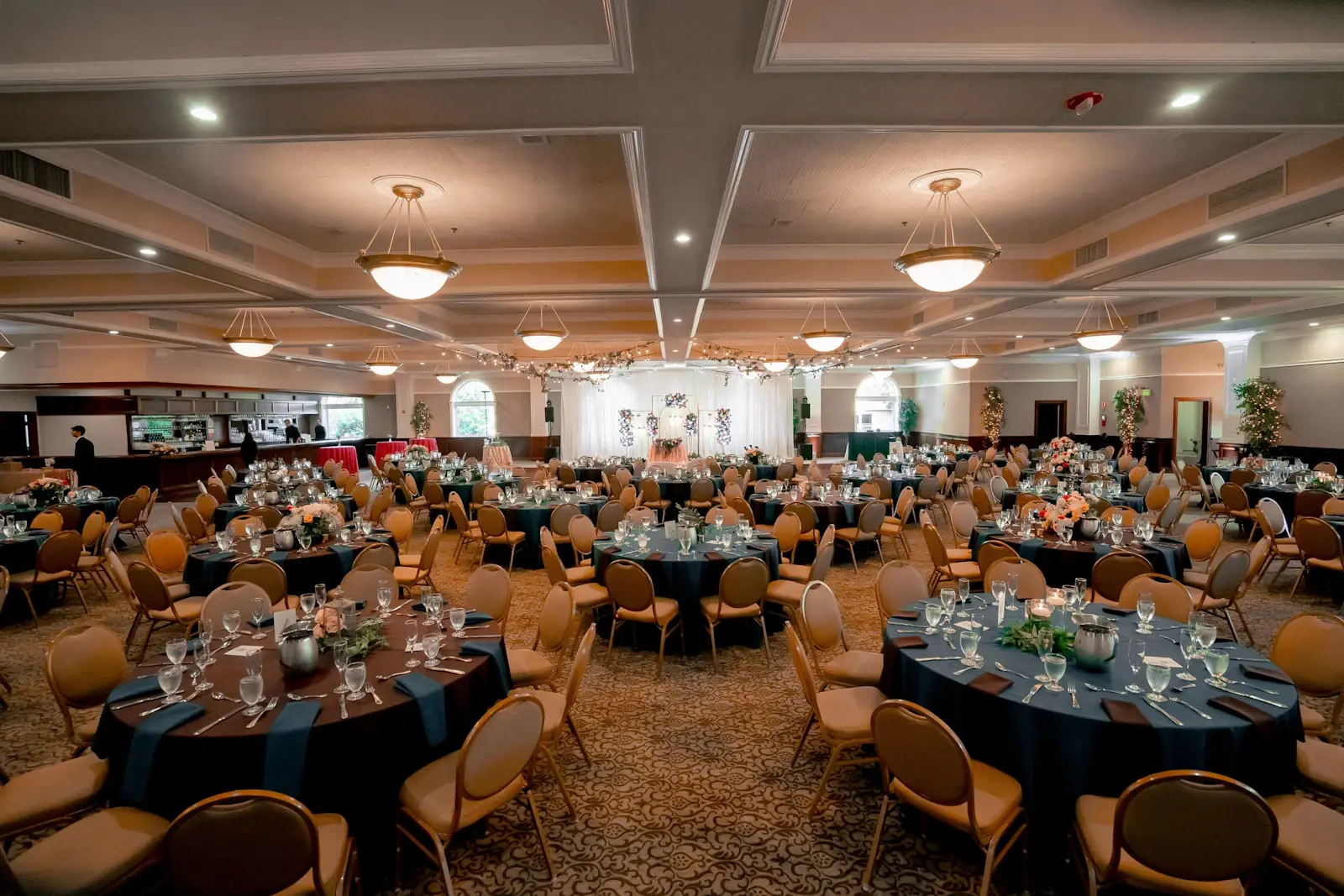 Large banquet hall set with round dining tables for a wedding