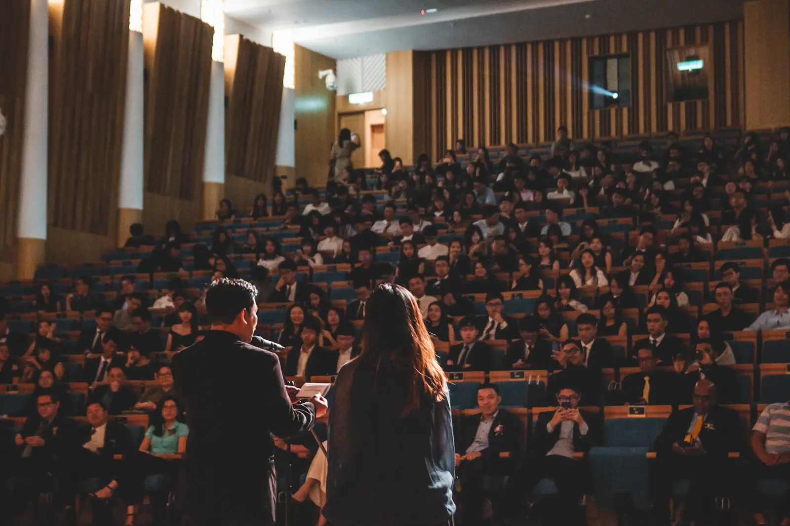 Conference hall with seated audience listening to a speaker