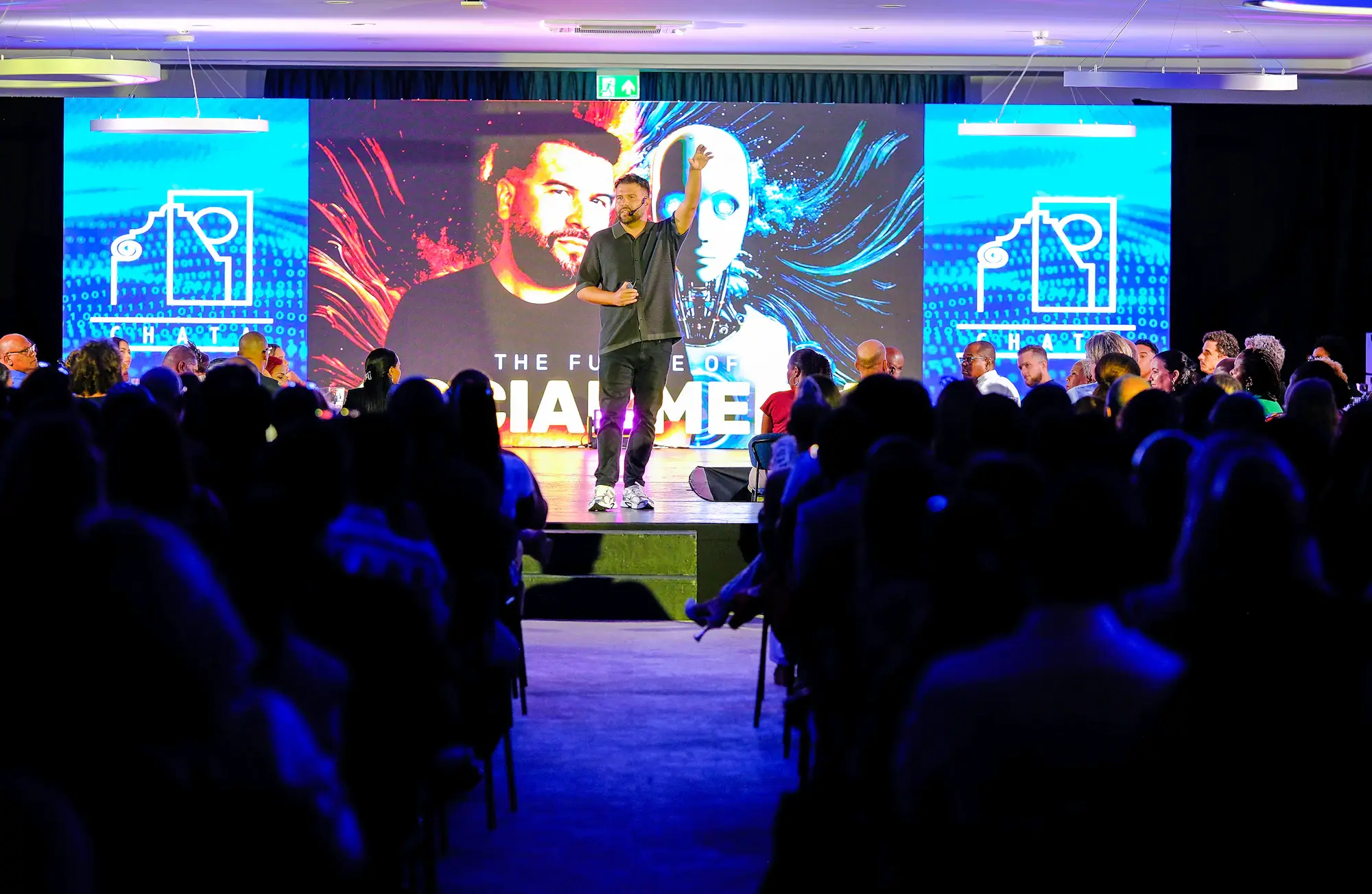 Corporate conference stage with large LED screens and audience