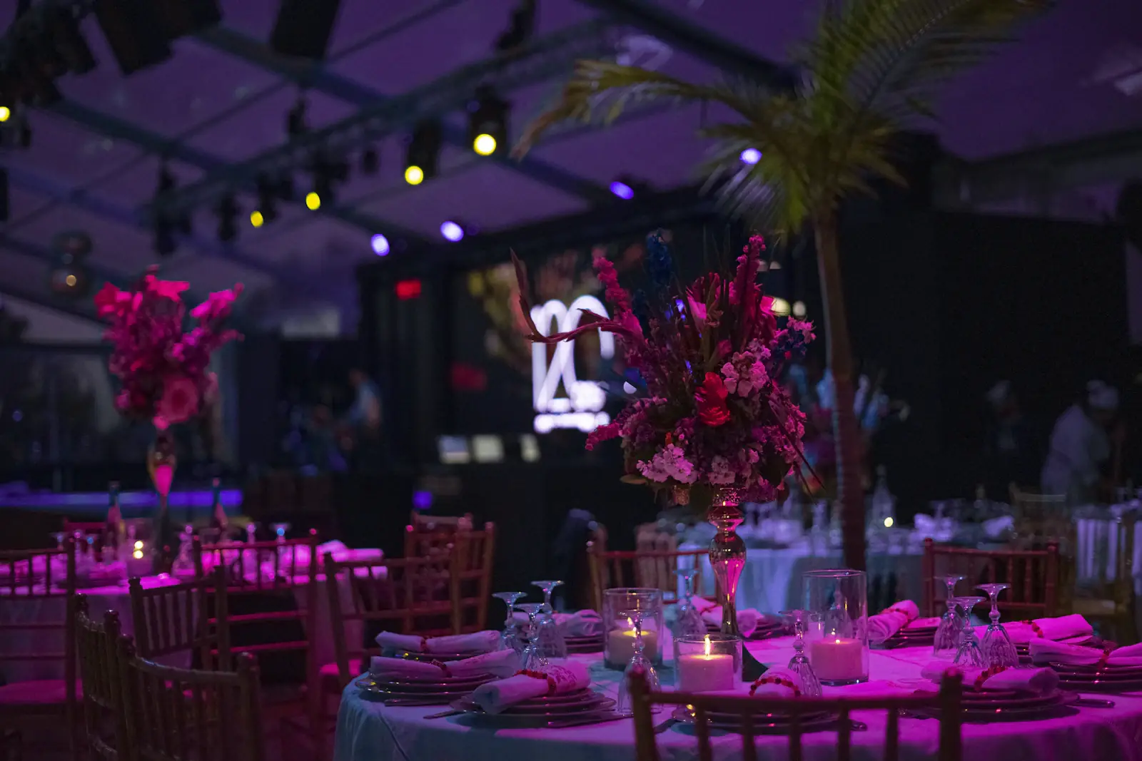 Event marquee with pink uplighting over reception tables