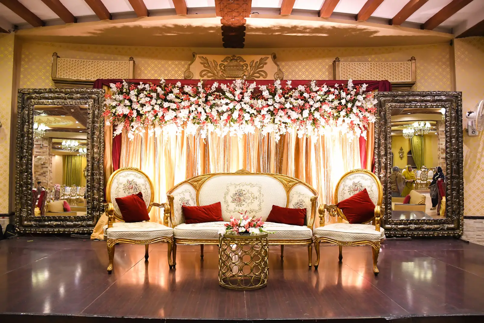 Elegant wedding stage with mirror frames, floral top and a royal sofa